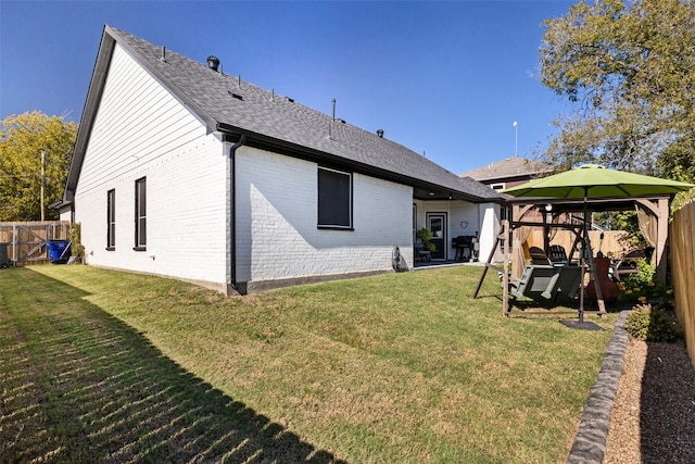 back of property with a gazebo and a lawn