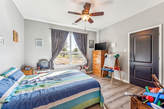 bedroom with light hardwood / wood-style floors and ceiling fan