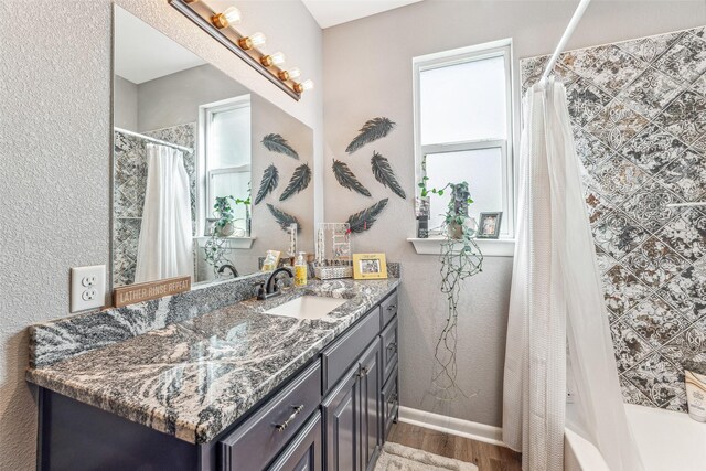 bathroom featuring hardwood / wood-style flooring, vanity, and shower / tub combo with curtain