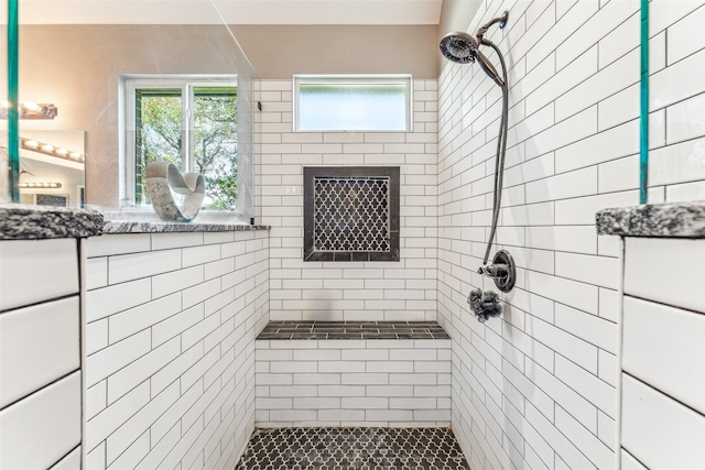 bathroom featuring tiled shower and a wealth of natural light