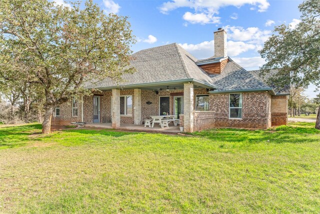 rear view of property with a yard, ceiling fan, and a patio area