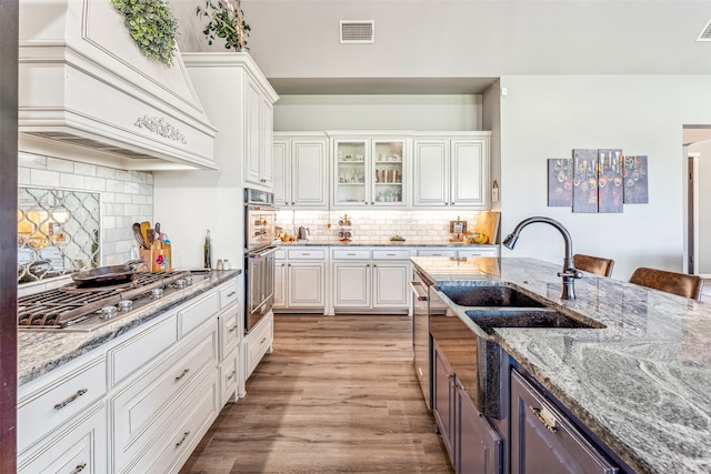 kitchen featuring light wood-type flooring, white cabinetry, and tasteful backsplash