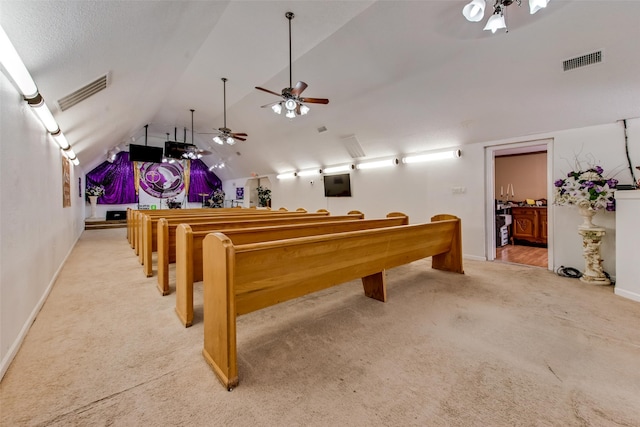 rec room with a textured ceiling, ceiling fan, light colored carpet, and lofted ceiling