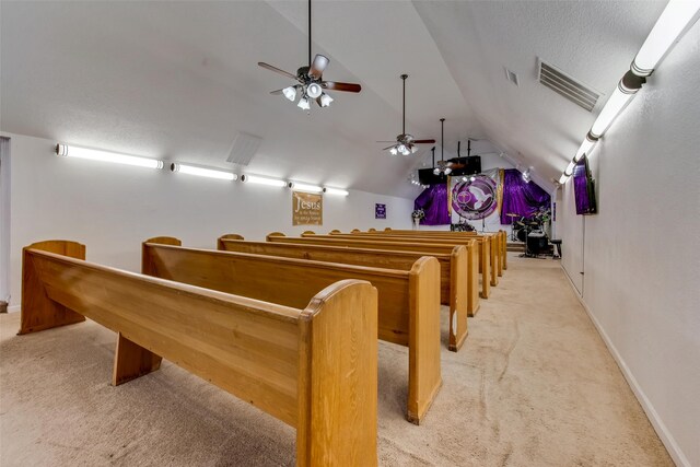 carpeted home theater room featuring a textured ceiling, ceiling fan, and lofted ceiling