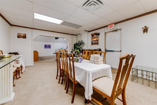 dining space featuring a paneled ceiling, light colored carpet, and ornamental molding