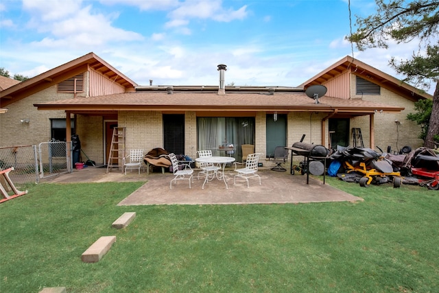 back of property featuring a lawn and a patio