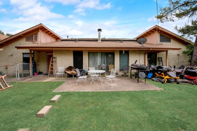 back of property featuring a lawn and a patio