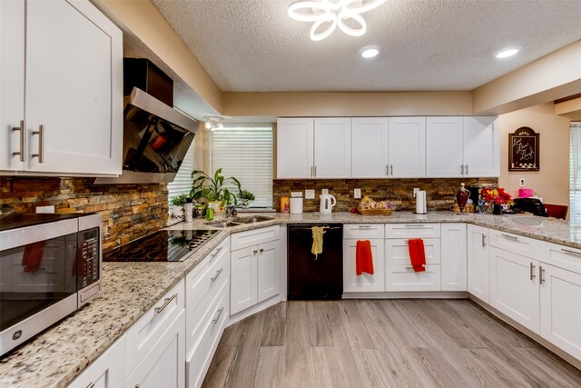 kitchen featuring black appliances, white cabinetry, and light hardwood / wood-style flooring