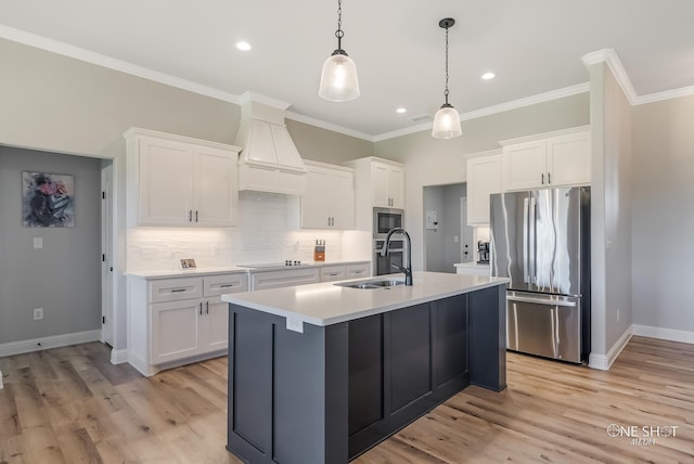 kitchen with white cabinets, hanging light fixtures, sink, and appliances with stainless steel finishes