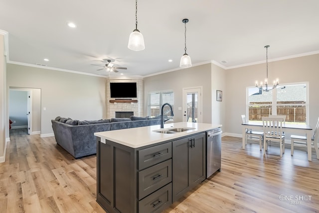 kitchen featuring dishwasher, ceiling fan with notable chandelier, sink, an island with sink, and light hardwood / wood-style floors