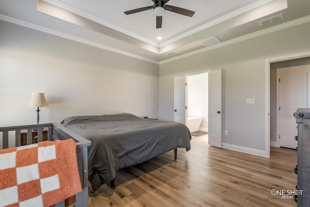 bedroom featuring ceiling fan, light hardwood / wood-style flooring, crown molding, and a tray ceiling