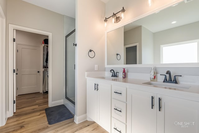 bathroom featuring wood-type flooring, vanity, and walk in shower