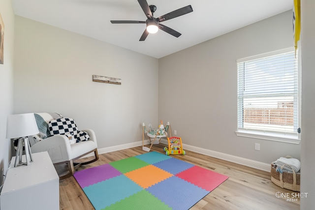 recreation room with ceiling fan, plenty of natural light, and wood-type flooring