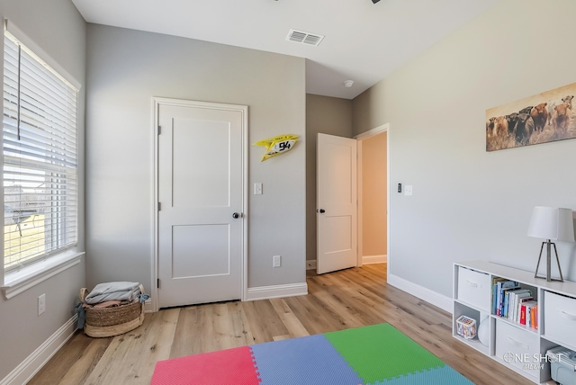 exercise room with light hardwood / wood-style flooring