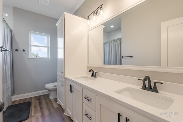 bathroom featuring hardwood / wood-style floors, vanity, and toilet