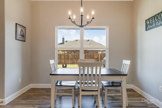 dining area featuring hardwood / wood-style flooring, a healthy amount of sunlight, and an inviting chandelier