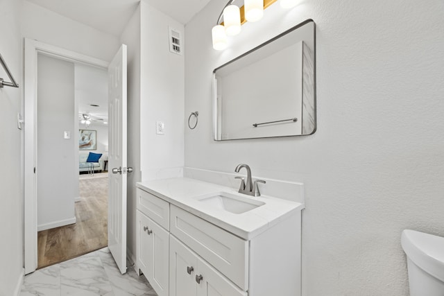 bathroom with vanity, ceiling fan, toilet, and wood-type flooring