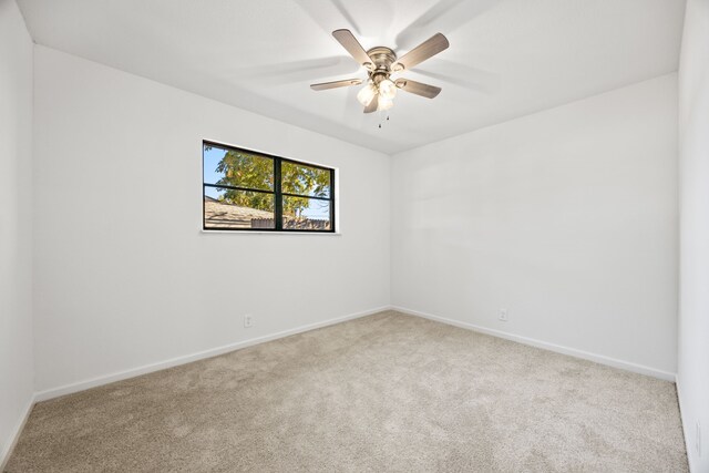 carpeted empty room featuring ceiling fan