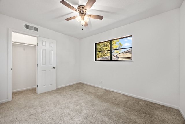 unfurnished bedroom featuring light colored carpet, a closet, and ceiling fan