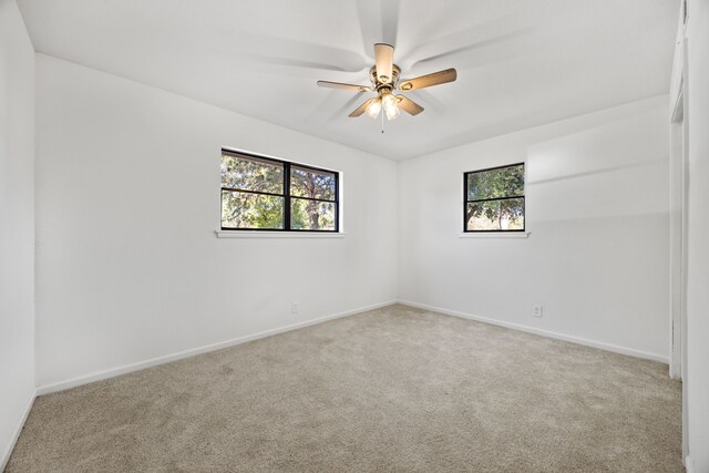 unfurnished room featuring ceiling fan and light colored carpet