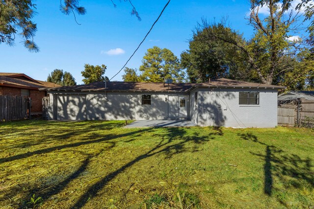 rear view of property featuring a lawn