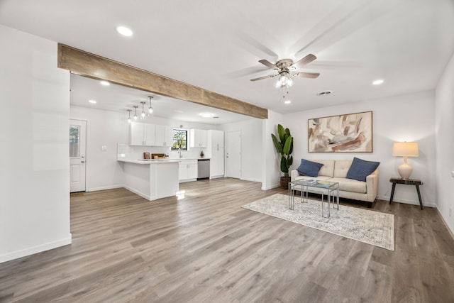 living room featuring ceiling fan, light hardwood / wood-style flooring, and sink