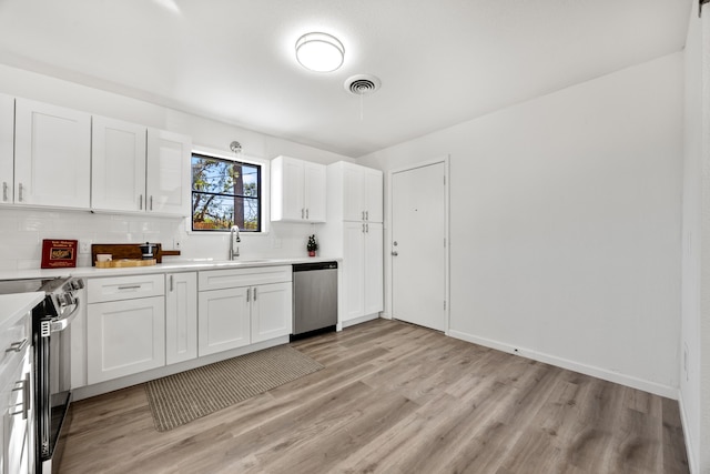 kitchen featuring light wood-type flooring, electric range oven, sink, dishwasher, and white cabinetry