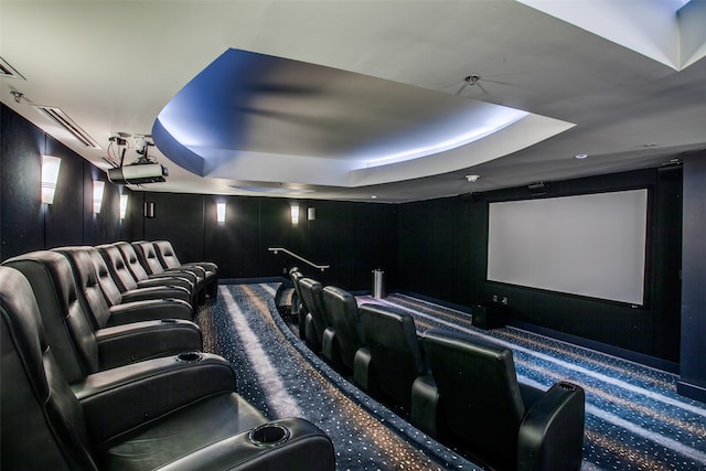 home theater featuring a tray ceiling and carpet