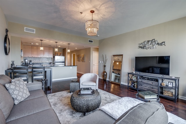 living room with hardwood / wood-style flooring and an inviting chandelier