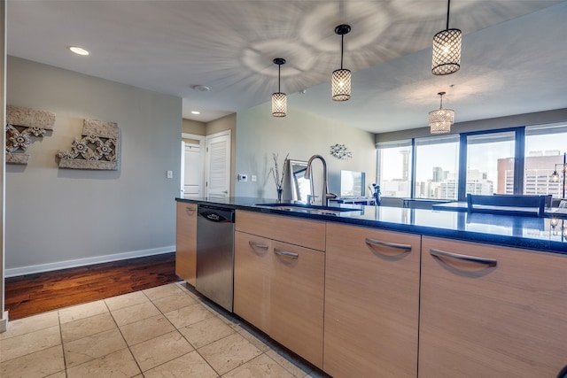 kitchen with dishwasher, sink, light wood-type flooring, and hanging light fixtures