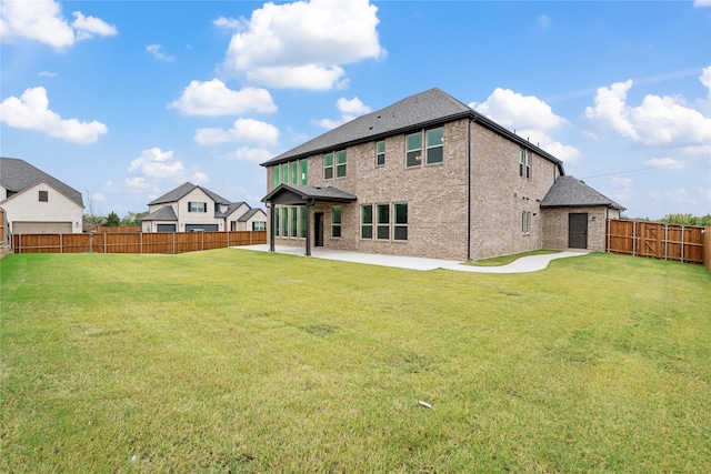 rear view of property featuring a yard and a patio area