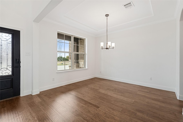 foyer entrance with crown molding, dark wood-type flooring, a raised ceiling, and a chandelier