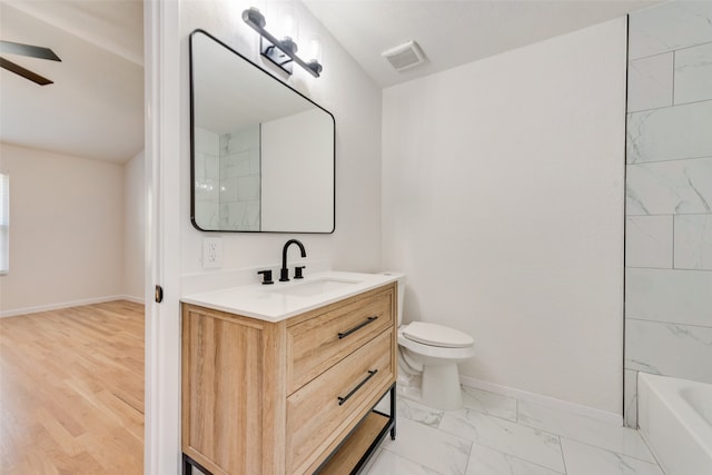 full bathroom featuring tiled shower / bath, hardwood / wood-style flooring, vanity, and toilet