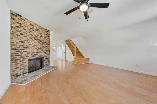 unfurnished living room with a fireplace, light hardwood / wood-style flooring, and ceiling fan