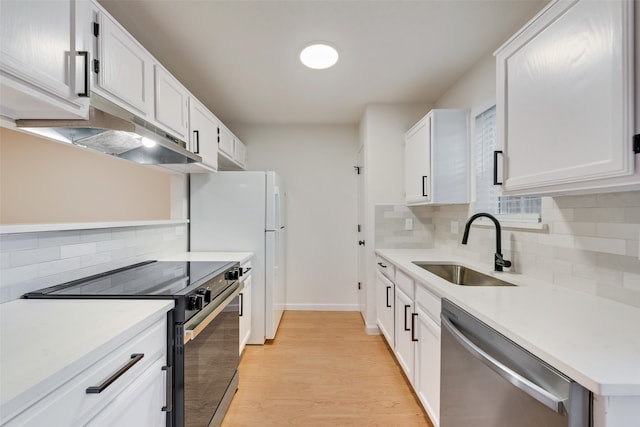 kitchen with white cabinets, appliances with stainless steel finishes, light hardwood / wood-style floors, and sink