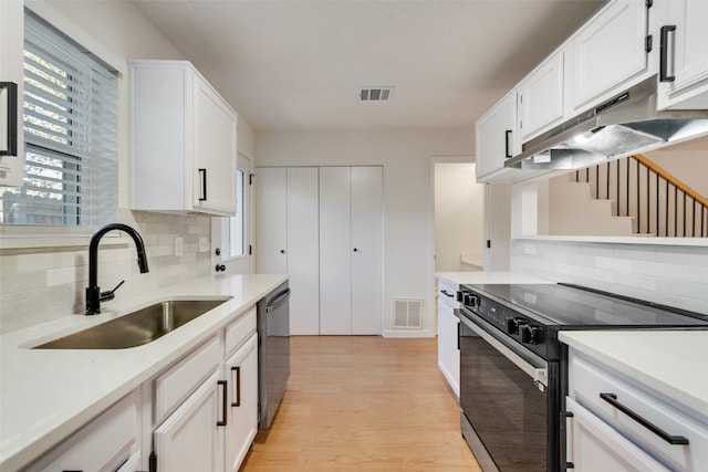 kitchen featuring sink, white cabinetry, stainless steel appliances, and light hardwood / wood-style flooring