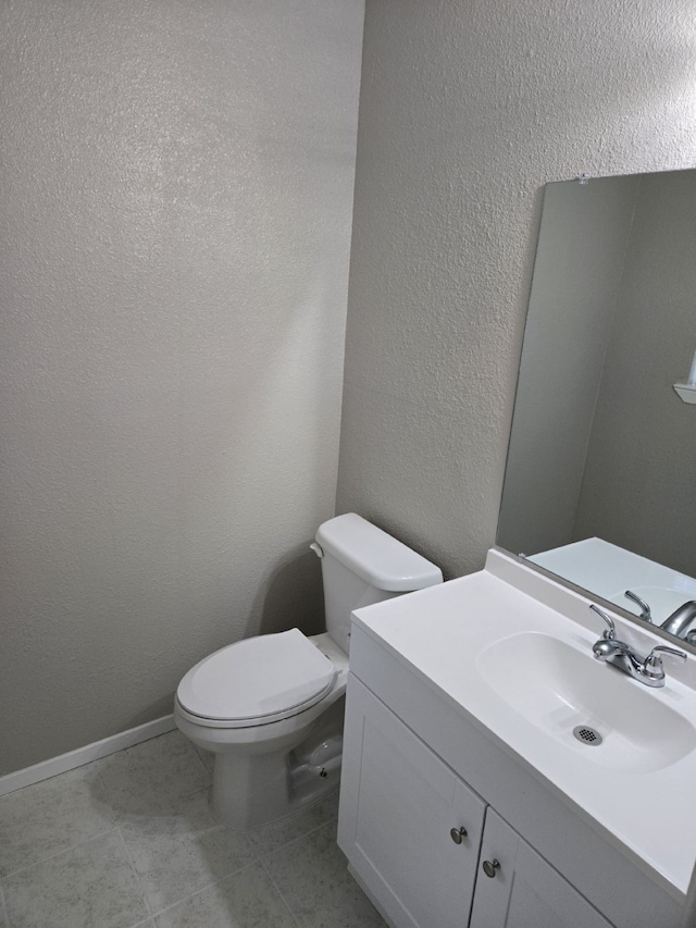 bathroom featuring tile patterned floors, vanity, and toilet