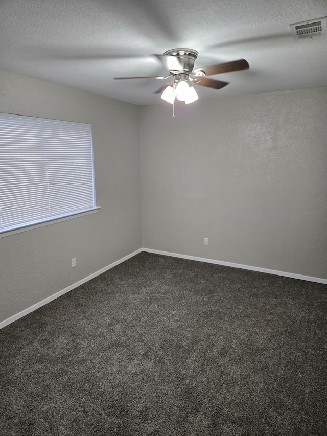 carpeted empty room with ceiling fan and a textured ceiling