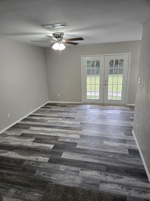 unfurnished room with a textured ceiling, ceiling fan, french doors, and dark hardwood / wood-style floors