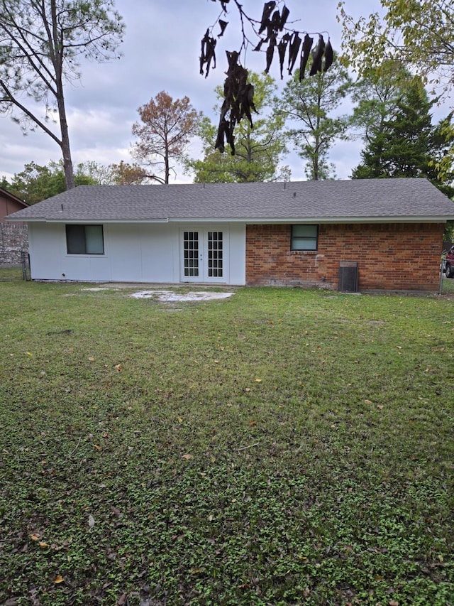 back of property featuring a yard and french doors