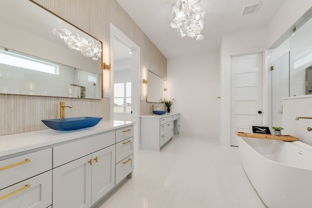 bathroom with visible vents, a soaking tub, walk in shower, vanity, and a notable chandelier