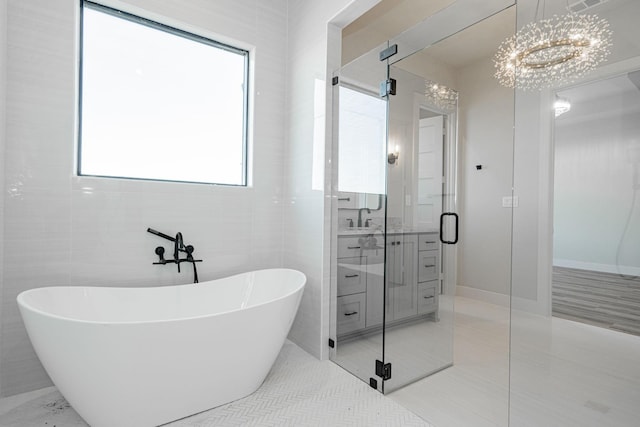 bathroom featuring tile patterned flooring, vanity, tile walls, and plus walk in shower