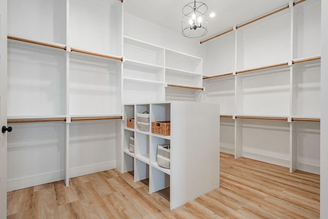 spacious closet featuring hardwood / wood-style flooring and a chandelier