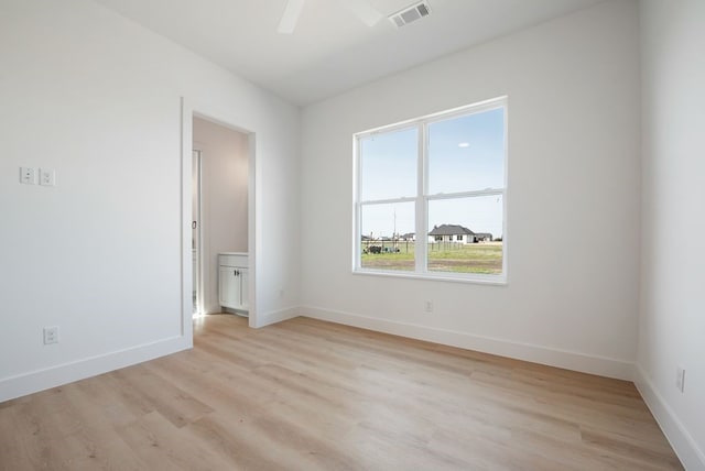 unfurnished room with light wood finished floors, baseboards, and visible vents