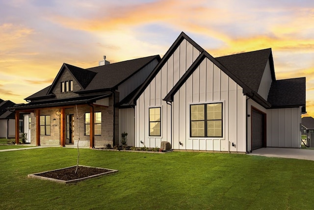 modern inspired farmhouse with a front lawn, board and batten siding, and an attached garage