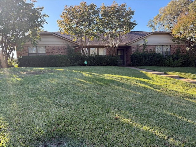 single story home featuring a front yard and brick siding