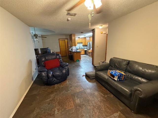 living room with a textured ceiling and ceiling fan