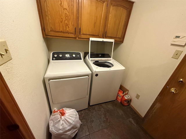 clothes washing area with separate washer and dryer, cabinets, and dark hardwood / wood-style floors