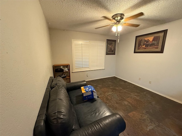 living area with baseboards, a textured ceiling, and a ceiling fan