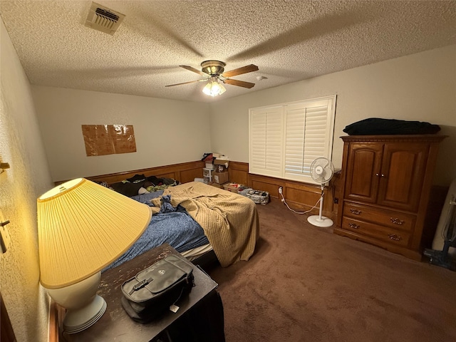 carpeted bedroom featuring ceiling fan and a textured ceiling